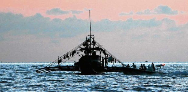 PANATAG FISHING Filipino fishermen catch fish near Panatag Shoal in the presence of Chinese Coast Guard vessels in this photo taken in 2016. —RICHARD A. REYES
