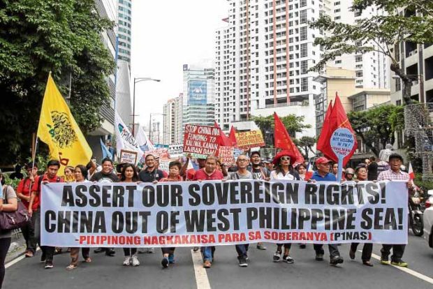 MAKATI MARCH Militants march to the Chinese Consulate in Makati City ahead of the arrival of Chinese President Xi Jinping on Tuesday, demanding that China vacate contested islets in the West Philippine Sea. —EARVIN PERIAS