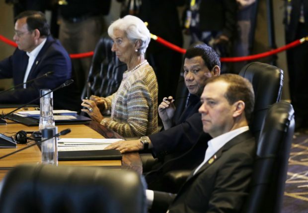 Philippine President Rodrigo Duterte, second from right, sits beside Russian Prime Minister Dmitry Medvedev, right, and Christine Lagarde, second from left, managing director of the IMF, during the IMF informal dialogue on the State of the Regional & Global Economy as part of APEC meet activities at Port Moresby, Papua New Guinea on Sunday, Nov. 18, 2018. (AP Photo/Aaron Favila)