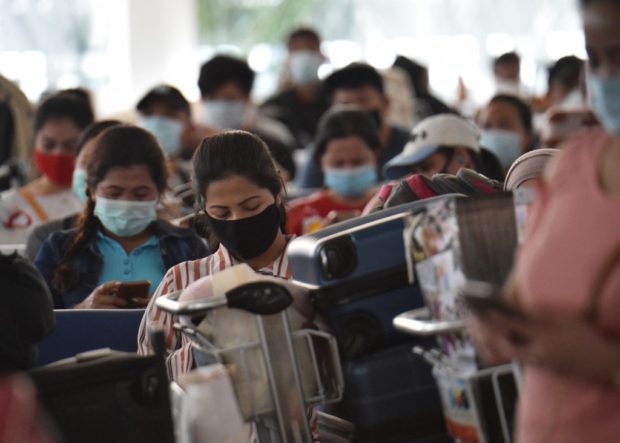 Philippine overseas workers who were quarantined for weeks after returning home wait for flights back to their home cities around the country, at Manila's international airport on May 28, 2020. - The Philippine government set up local flights to send thousands of migrant workers stuck in quarantine facilities in Manila back home in an effort to free up crowded quarantine facilities, ahead of new arrivals from overseas