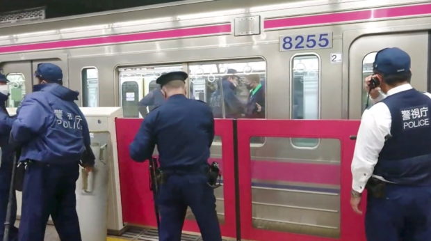 Police officers work at a scene following a knife, arson and acid attack at a Tokyo train line, in Tokyo, Japan October 31, 2021 in this still image obtained from a social media video. TWITTER / @SIZ33/via REUTERS THIS IMAGE HAS BEEN SUPPLIED BY A THIRD PARTY. MANDATORY CREDIT. NO RESALES. NO ARCHIVES.