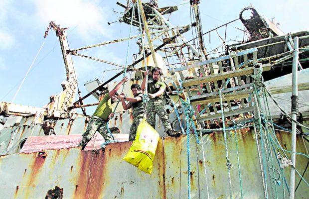 This photo taken on March 29, 2014, shows Philippine Marine troops stationed on the rusting BRP Sierra Madre at Ayungin Shoal receiving fresh supplies.
