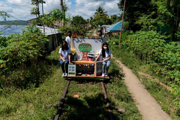 Student volunteers ride on their makeshift trolley which serves as a mobile library for children, in Tagkawayan, Quezon Province, Philippines, February 15, 2022. Picture taken February 15, 2022. REUTERS/Lisa Marie David