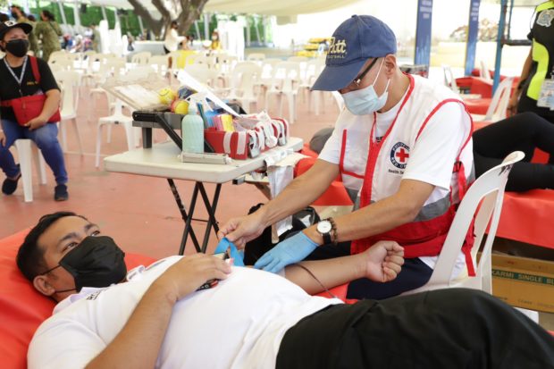 Red Cross Volunteer getting blood from a donor in Quezon City