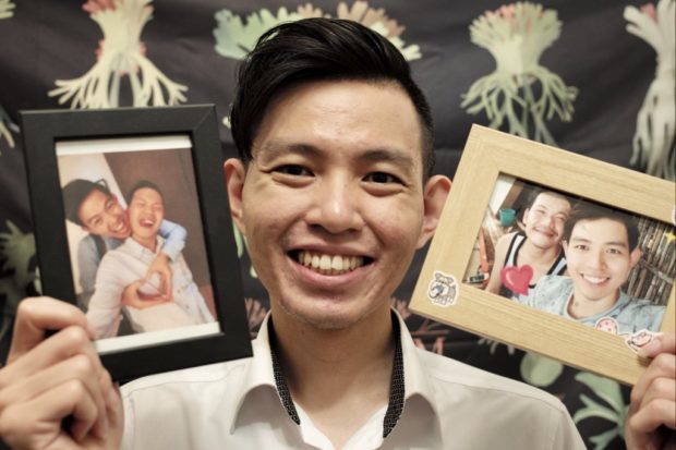 In this photo taken on May 12, 2022, Vincent Chuang, a Taiwanese teacher, shows pictures with his Philippine partner Andrew Espera at home in New Taipei City. - Taiwan's LGBTQ community celebrated the third year of gay marriage being legal this week but for Vincent Chuang it was a bittersweet reminder that he still cannot wed because he fell in love with a foreigner. (Photo by Sam Yeh / AFP) / To go with AFP story Taiwan-politics-rights-marriage-LGBTQ, FOCUS by Amber WANG