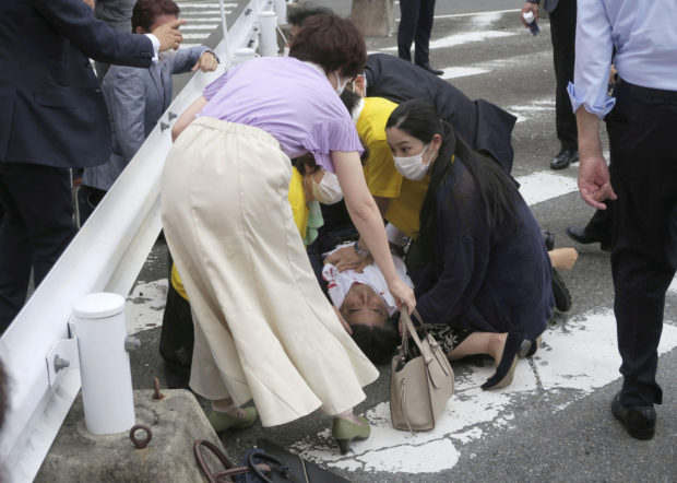 Former Japanese prime minister Shinzo Abe lies on the ground after apparent shooting during an election campaign for the July 10, 2022 Upper House election, in Nara, western Japan July 8, 2022. in this photo taken by Kyodo. Mandatory credit Kyodo via REUTERS