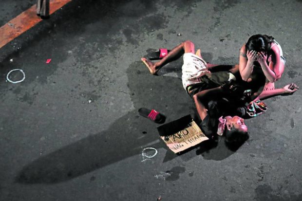 EJK VICTIM | Jennelyn Olaires weeps beside her partner, alleged drug pusher Michael Siaron, 30, a pedicab driver who was shot and killed by unidentified suspects in July 2016. (INQUIRER FILE PHOTO)