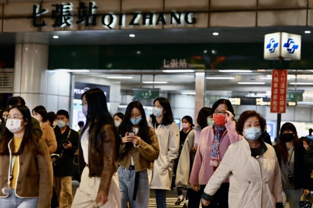 Commuters exit a Mass Rapid Transport (MRT) station in Xindian in New Taipei City on January 3, 2022, after a strong earthquake struck off the coast of eastern Taiwan with shaking felt in the capital Taipei. (Photo by Sam Yeh / AFP)