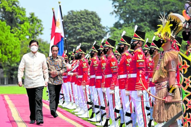 WELCOME HONORS Indonesian President Joko Widodo (second from left) walks with Philippine President Marcos as they inspect the honor guards at the Presidential Palace in Bogor, Indonesia, on Monday. Indonesia is hosting Mr. Marcos’ first official foreign visit since he assumed the presidency on June 30. —REUTERS. STORY: PH, Indonesia sign agreements on economic cooperation, defense