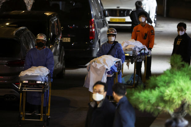 People move bodies to be transported from hospital, after a stampede during a Halloween festival in Seoul, South Korea, October 30, 2022. REUTERS/Kim Hong-ji