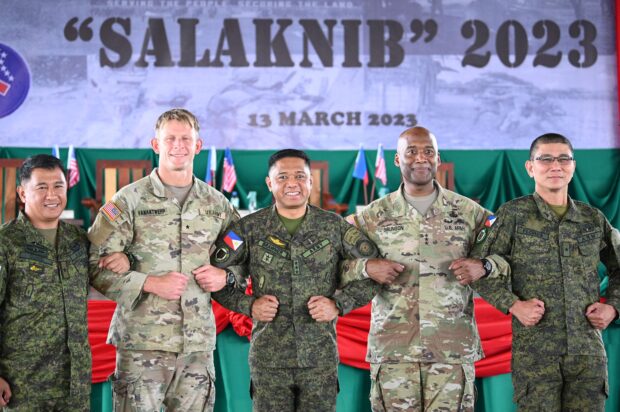 ALLIES Lt. Gen. Romeo Brawner Jr., Philippine Army chief (thirdfrom left), and Lt. Gen. Xavier Brunson, commanding general of the US Army I Corps (fourth from left), link arms with other army officials from both countries to symbolize their alliance and friendship as joint military exercises start on Monday. —AFP