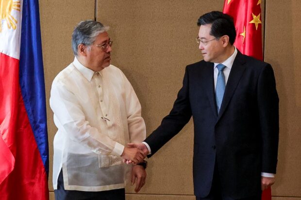 China's Foreign Minister Qin Gang (R) is welcomed by the Department of Foreign Affairs Secretary Enrique Manalo ahead of their meeting at the Diamond Hotel in Metro Manila on April 22, 2023. (Photo by Gerard CARREON / POOL / AFP)