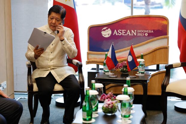 Philippines' President Ferdinand "Bongbong" Marcos Jr. speaks on a phone while waiting for a bilateral meeting on the sidelines of the Association of Southeast Asian Nations (ASEAN) Summit held in Labuan Bajo on May 10, 2023. (Photo by WILLY KURNIAWAN / POOL / AFP)