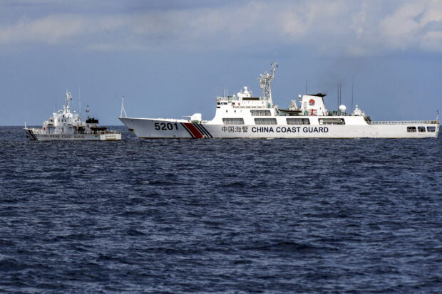 HARASSMENT ON HIGH SEAS This photo taken on April 23, 2023, shows the Philippine Coast Guard vessel BRP Malapascua (left) maneuvering as a Chinese coast guard ship cuts its path at Ayungin (Second Thomas) Shoal in the Spratly Islands in the disputed South China Sea. —AFP