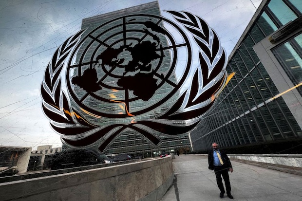 Person walking outside UN headquarters near UN logo. STORY: Engaging UN in PH row with China needs careful study – Teodoro