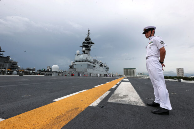 A sailor from the Japan Maritime Self-Defense Force stands guard as JS Izumo docks at Pier 15 in South Harbor, Manila, on Sunday, Aug. 27, 2023.