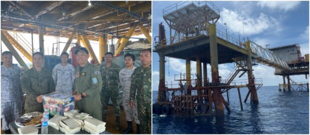 Soldiers assigned to the Nido observation post, a former gas platform turned over to the Armed Forces of the Philippines in 2019, are treated with food on Aug. 22, 2023, by visiting officers of the Western Command.
