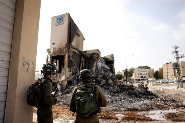 Israeli soldiers look at the remains of a police station which was the site of a battle following a mass infiltration by Hamas gunmen from the Gaza Strip, in Sderot, southern Israel October 8, 2023. REUTERS/Ronen Zvulun
