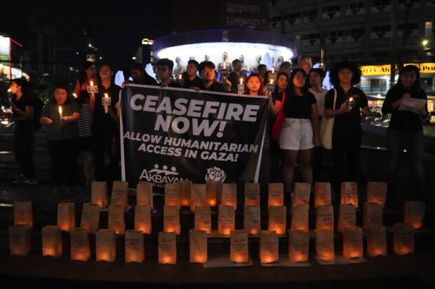 Activists light candles and say prayers as they call for an immediate ceasefire and the establishment of a humanitarian corridor to ensure the safe passage of aid and civilians trapped during the Israel and Palestinian conflict as they gathered on Friday, Oct. 20, 2023 in Quezon City.
