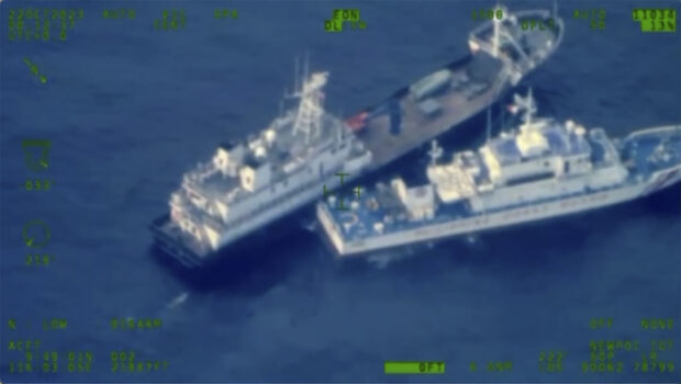 This image released by the Armed Forces of the Philippines, shows a Chinese militia vessel, top, and Philippine coast guard vessel BRP Cabra as they approach Second Thomas Shoal, locally called Ayungin Shoal, at the disputed South China Sea on Sunday Oct. 22, 2023. 