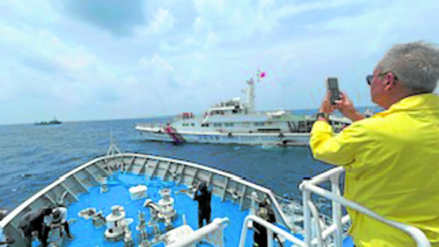ENVOY ONBOARD With a China Coast Guard vessel passing in front of him, former ForeignSecretary Teodoro Locsin Jr., Manila’s special envoy to Beijing, sees for himself
the harassment of a Filipino supply mission to the BRP Sierra Madre at Ayungin Shoal on Oct. 4. —Frances Mangosing/ PHILIPPINE DAILY INQUIRER