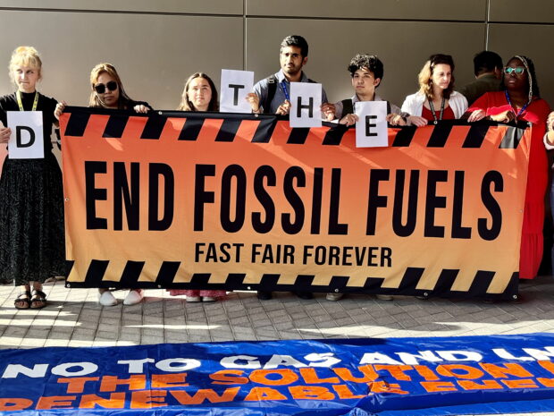 URGENT CALL Climate activists gather outside the main venue of the COP28 talks in Dubai on Sunday to reiterate their call for countries to junk fossil fuels. —IMELDA V. ABAÑO