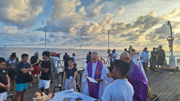 MASS AT SEA Catholic priest Robert Reyes celebrates a Holy Mass aboard TS Kapitan Felix Oca midway to the journey of the civilian-led “Christmas convoy” to Lawak (Nanshan) Island in the Spratlys. —GERALDFORD TICKE