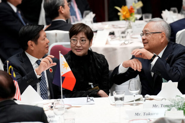 IMPORTANT MEETING President Marcos speaks with Tetsuro Tomita, chair of the Board of Councillors of Keidanren (Japan Business Federation), at the 50th anniversary of Asean-Japan Friendship and Cooperation luncheon meeting in Tokyo, Japan, on Monday. —REUTERS