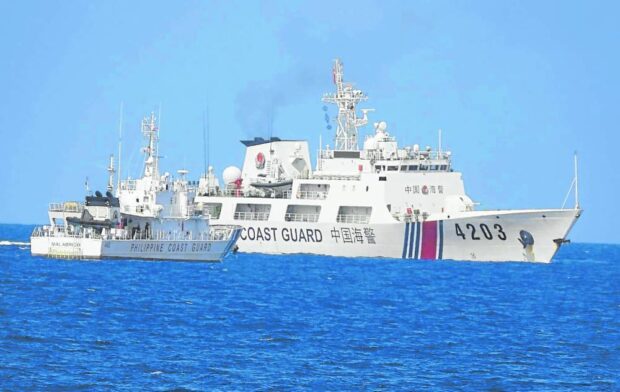 CLOSE QUARTERS A China Coast Guard vessel closely guardsa Philippine Coast Guard ship supporting a resupply mission to Ayungin (Second Thomas) Shoal in June last year. 