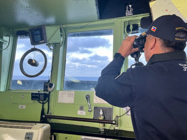 From the bridgeof the BRP Gregorio del Pilar, Western Command chief Vice Adm. Alberto Carlos peers through binoculars for a better look at a Chinese frigate that was already there when they arrived. 