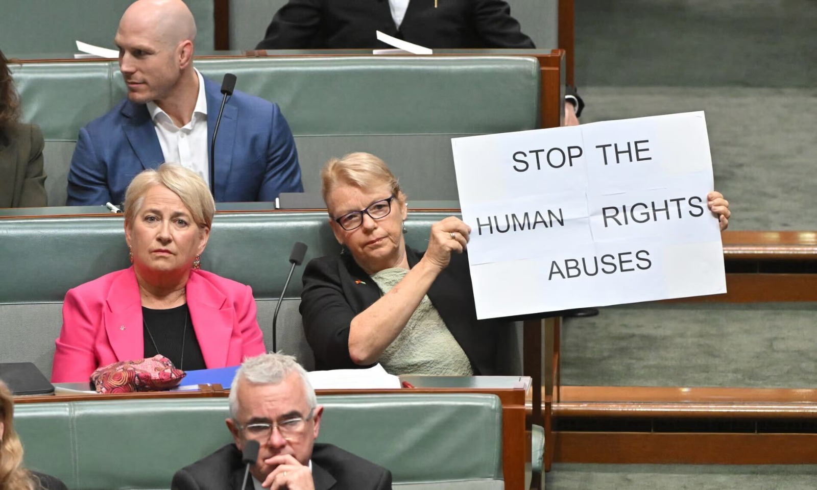 Australian senator Janet Rice, during President Ferdinand “Bongbong” Marcos Jr. 's address to the Australian Parliament on Thursday, pulls up a placard urging the president to “stop the human rights abuses."