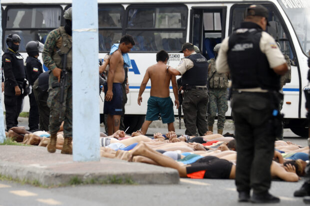 Police keep watch over arrested men who attempted to take over a hospital in Guayas, Ecuador, on January 21, 2024. Police in violence-plagued Ecuador arrested 68 people Sunday who had attempted to take over a hospital in the country's southwest in the midst of a "war" between drug gangs and the security forces.STRINGER / AFP
