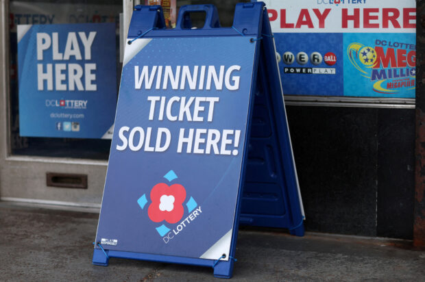 Lottery ticket signs advertising the Mega Millions and Powerball games can be seen in Washington, U.S., July 17, 2023. REUTERS/Leah Millis/File Photo