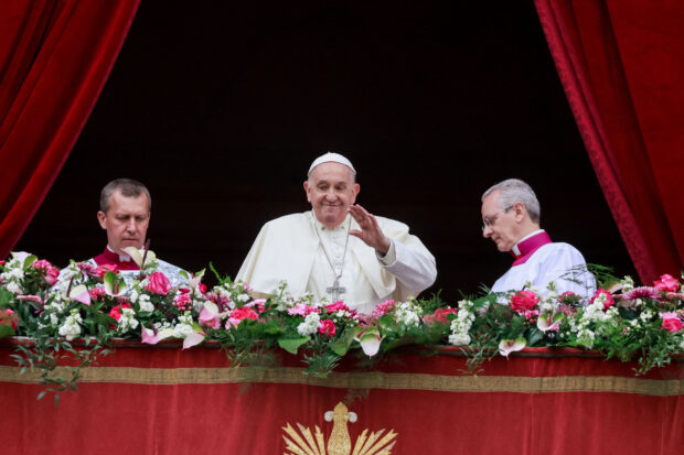 Pope Francis waves from a balcony, on the day he delivers his "Urbi et Orbi" (To the city and the world) message at St. Peter's Square, on Easter Sunday, at the Vatican.
