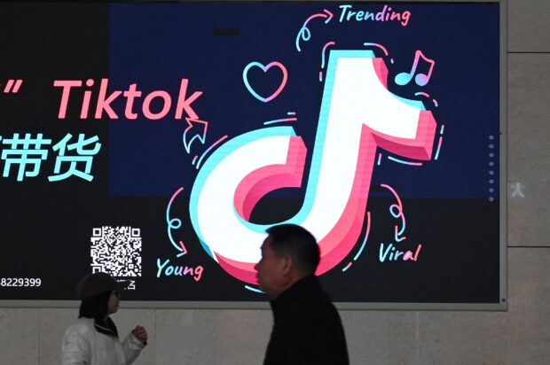 TRENDSETTER People walk past an advertisement featuring the TikTok logo at a train station in Zhengzhou, in China’s central Henan province in January. China this month slammed the approval of a US bill that will ban TikTok unless it severs ties with its Chinese parent company. —AFP