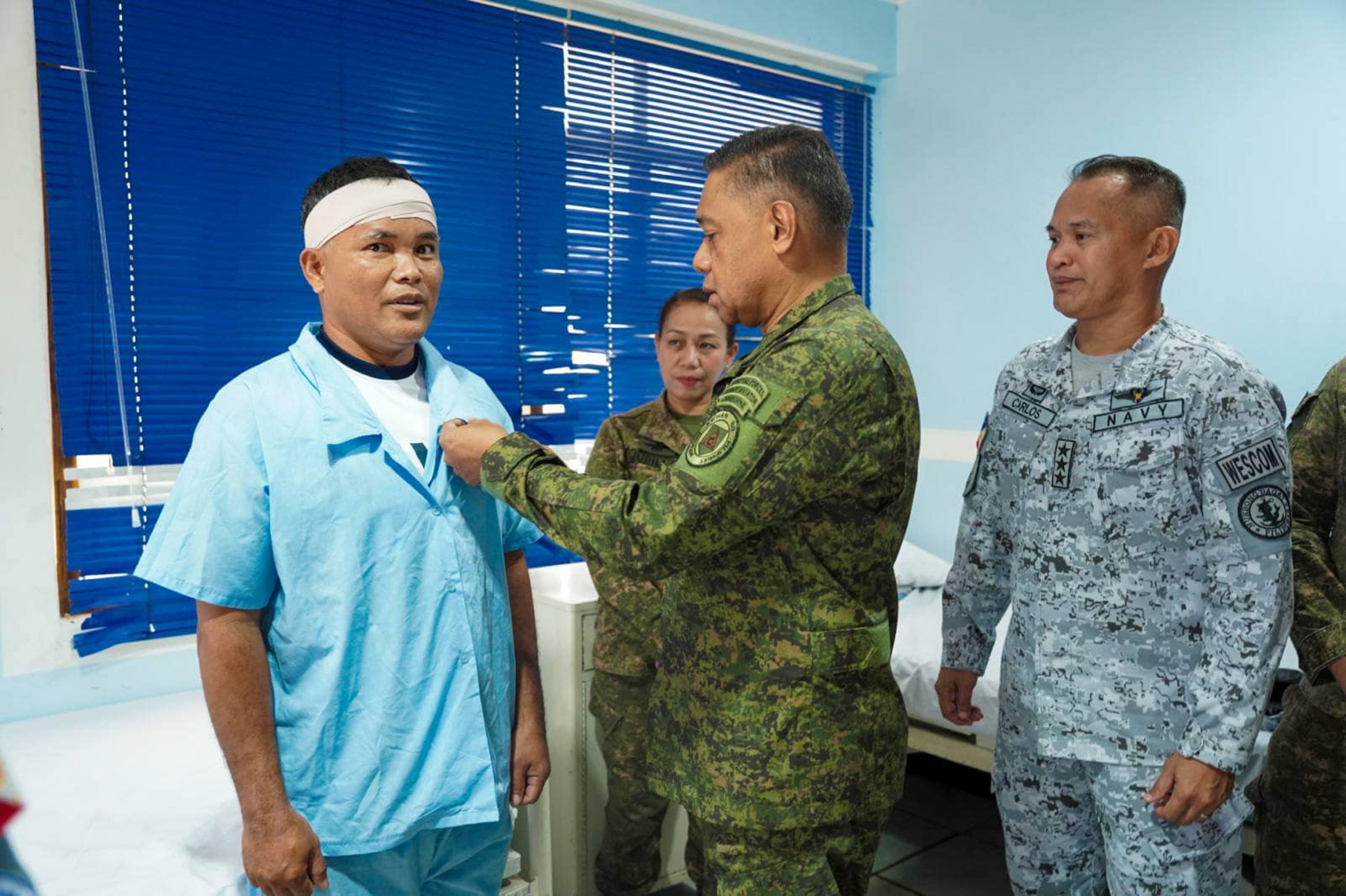 One of the Navy personnel injuredin the March 23 water cannon attack receives a medal from Gen. Romeo Brawner Jr.
