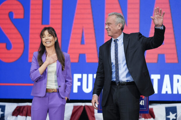Presidential candidate Robert F. Kennedy Jr. right, waves on stage with Nicole Shanahan, after announcing her as his running mate
