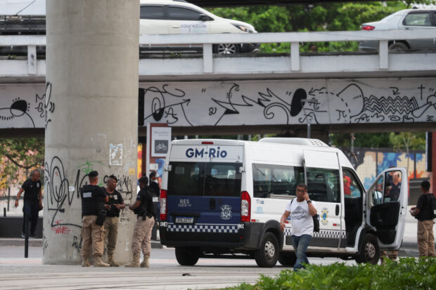 Municipal guards gather near the bus terminal station after a man hijacked a bus with passengers, in Rio de Janeiro