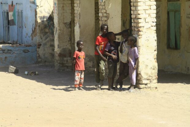 Displaced Sudanese children stand in the courtyard of a school, where their families took refuge