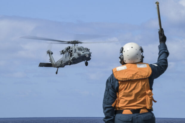 A helicopter from the USS Carl Vinson lands on the deck of the Japan Maritime Self-Defense Force's Hyuga-class helicopter destroyer "JS Ise" during a three-day maritime exercise between the US and Japan in the Philippine Sea on January 31, 2024.