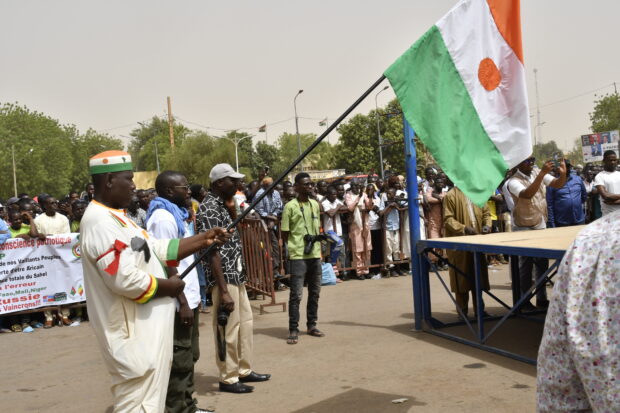 A man holds a flag of Niger as protesters gather during a demonstration for the immediate departure of United States Army soldiers deployed in northern Niger in Niamey, on April 13, 2024. Thousands of people demonstrated on April 13, 2024 in Niger’s capital Niamey to demand the immediate departure of American soldiers based in northern Niger, after the military regime said it was withdrawing from a 2012 cooperation deal with Washington. (Photo by AFP)