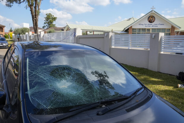 A damaged car sits parked outside the Christ the Good Shepherd church in suburban Wakely in western Sydney, Australia, 