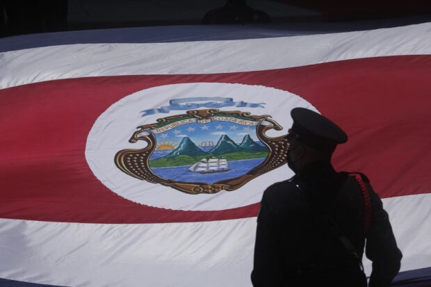 An honor guard stands next to a Costa Rican national flag during the inauguration ceremony of Costa Rica's new President Rodrigo Chaves in San Jose, on May, 8, 2022