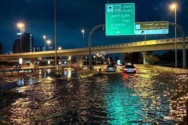 Motorists drive along a flooded street following heavy rains in Dubai early on April 17, 2024.