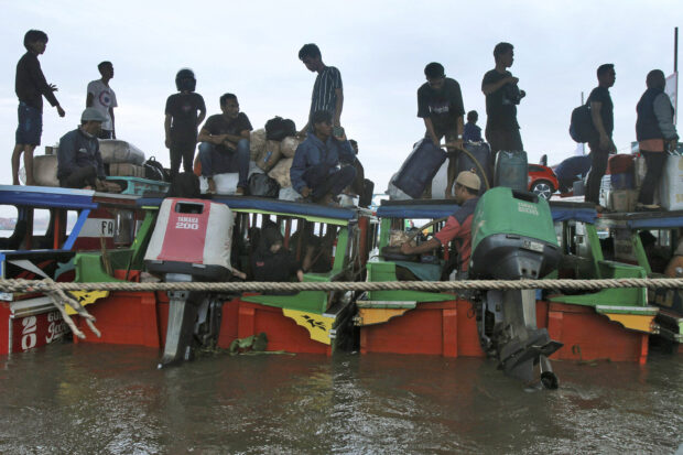 People board boats as they travel to their home villages to celebrate Eid al-Fitr holiday