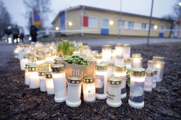 Candles and flowers placed on a square in front of the Viertola School 