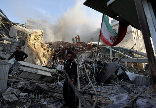 Emergency services work at a building hit by an air strike in Damascus, Syria, Monday, April 1, 2024.