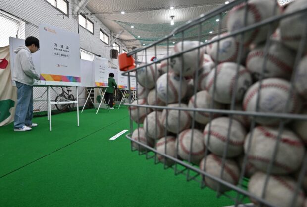 South Koreans cast their ballots during the parliamentary elections at a polling station located in a baseball training center