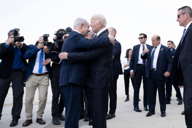 Israel Prime Minister Benjamin Netanyahu (L) hugs US President Joe Biden upon his arrival at Tel Aviv's Ben Gurion airport on October 18, 2023, amid the ongoing battles between Israel and the Palestinian group Hamas. Biden landed in Israel on October 18, on a solidarity visit following Hamas attacks that have led to major Israeli reprisals. (Photo by Brendan Smialowski / AFP)