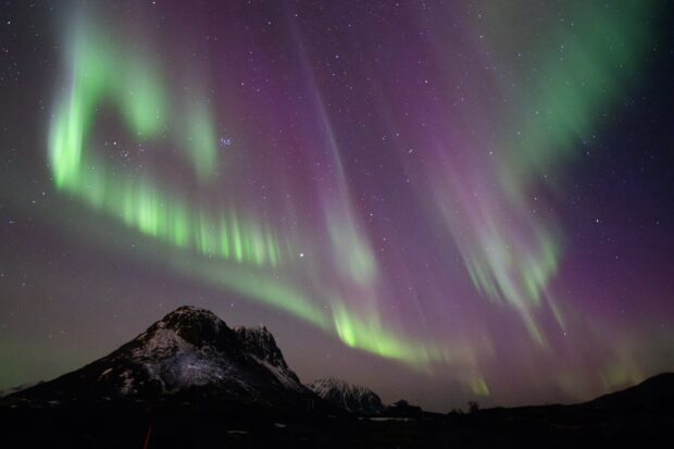 This picture shows northern lights (Aurora Borealis) over the mountain at Utakleiv on March 3, 2024 in Lofoten Islands. A huge solar storm is heading for Earth, supercharging auroras and bringing possible disruptions to satellites and power grids as early as the evening of May 10, 2024, US officials say.
